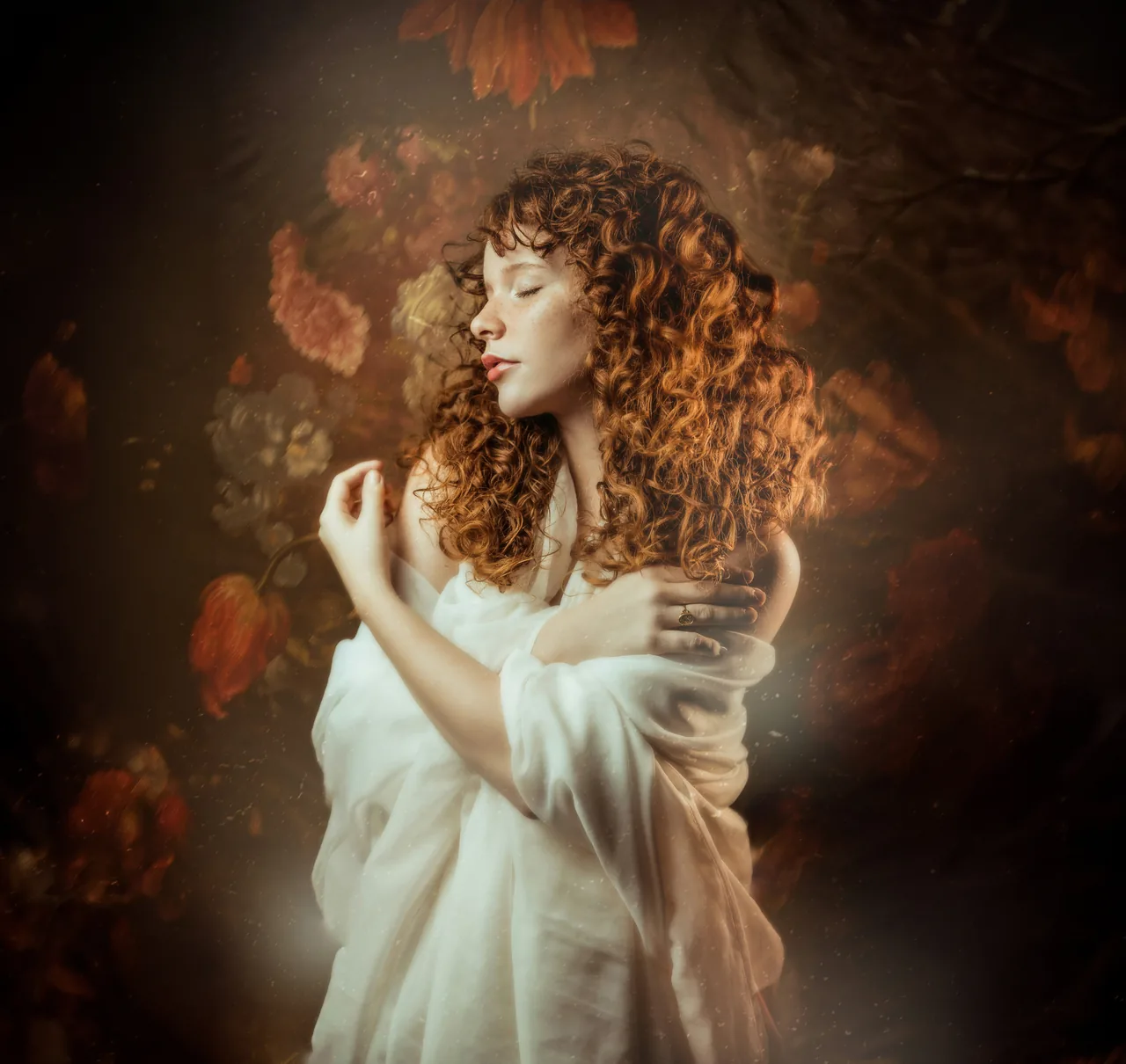 A woman with closed eyes, wrapped in white