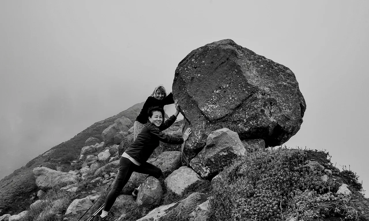 A woman pushing a great boulder up a mountainside